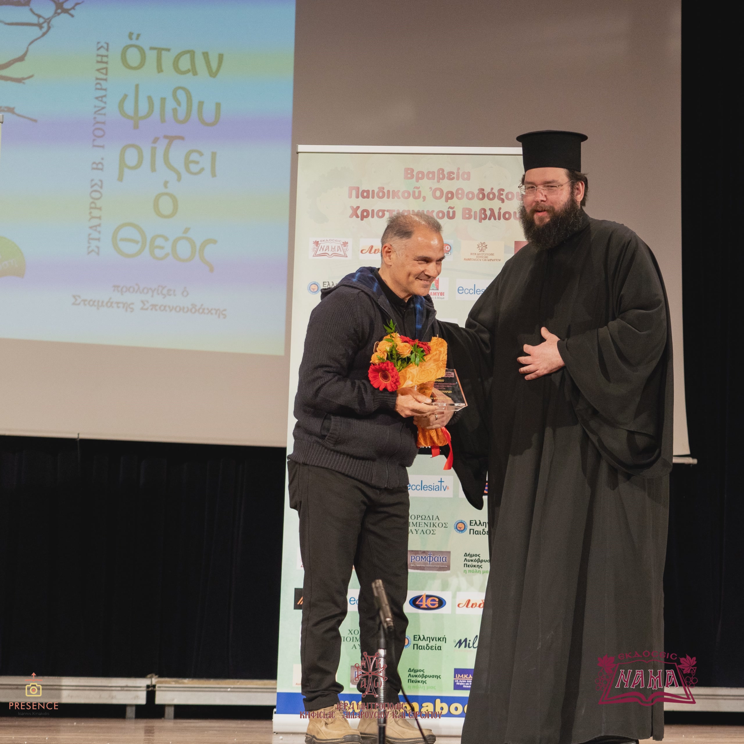 Ο κύριος Χρήστος Γουναρίδης παραλαμβάνει το βραβείο από τον Γενικό Αρχιερατικό Επίτροπο π. Χρίστο Κυριακόπουλο.